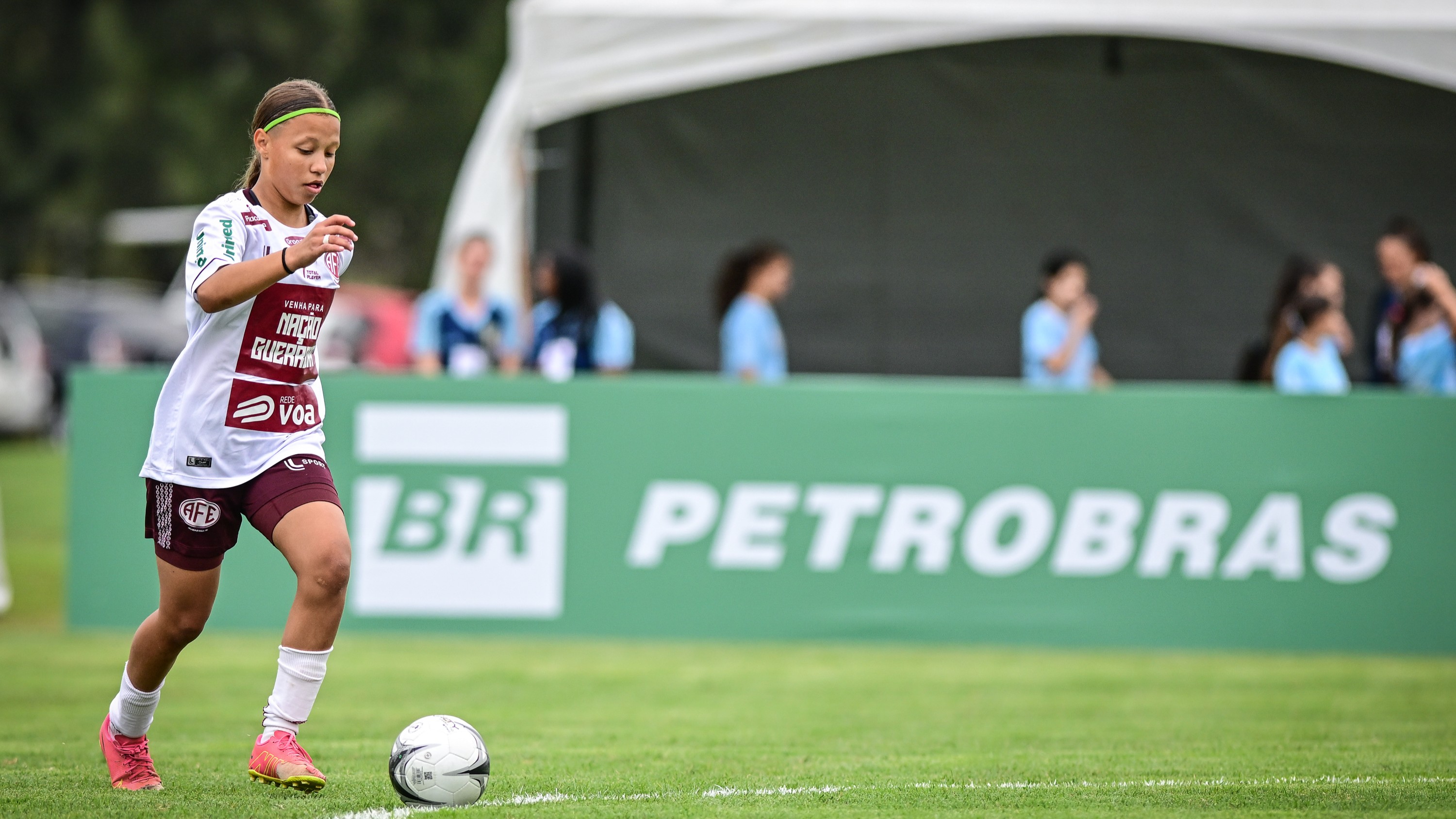Jogadora disputando partida pelo campeonato de futebol feminino